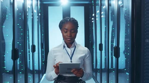 A Professional Woman Engaged in Important Work Within a Data Center Using a Tablet Device