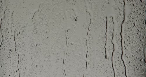 Wet Glass Surface with Raindrops on Light Background
