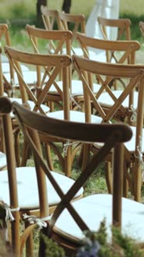 VERTICAL VIDEO Outside Wedding Ceremony in Park Among the Trees Dolly Shot of Wooden Chairs with