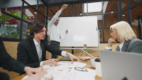 Diverse Team Collaborates During Office Presentation