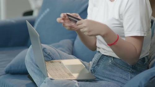 Woman Using Laptop and Holding Credit Card