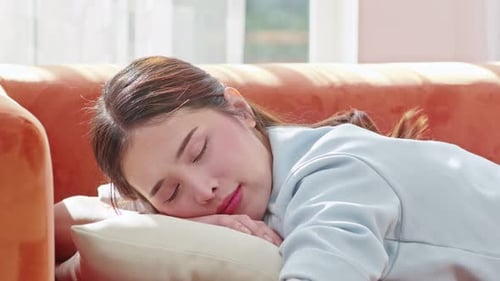 Woman Sleeping Peacefully on Orange Couch