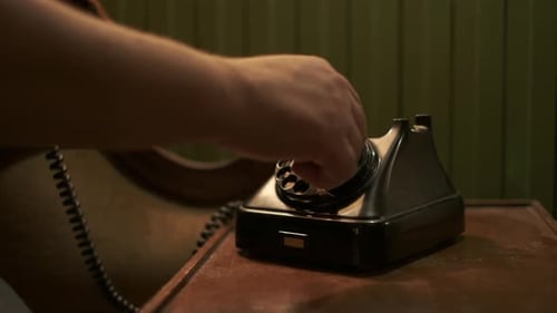 Passer un appel téléphonique sur un vieux téléphone des années 90. La main d'un homme décroche le téléphone et compose un
numéro
