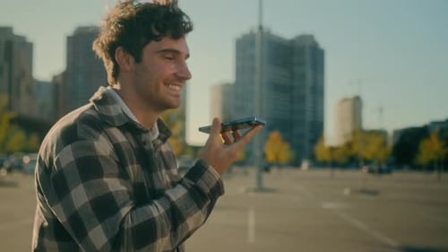 Happy Caucasian Man Recording Voice Message in Smartphone Walking City Street Smiling Guy Chatting