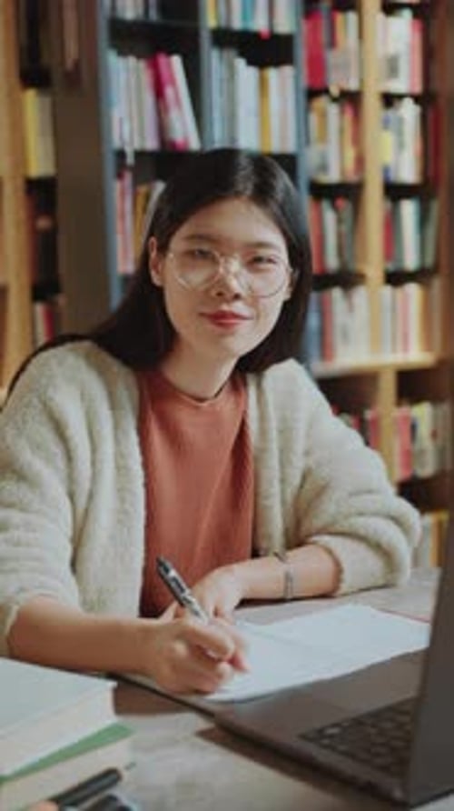 Portrait of Pretty Asian Girl Studying at Desk in Public Library