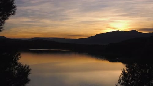 Sunset reflecting in calm lake timelapse