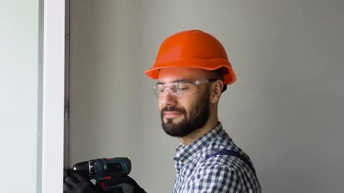 Man in Uniform Does Pvc Window Installation with a Screwdriver in Office or Apartment