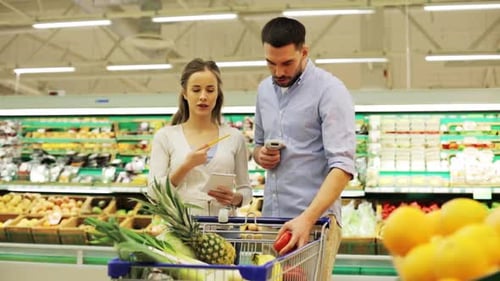 Jovem casal hispânico feliz digitaliza mantimentos no corredor do supermercado com leitor de código de barras