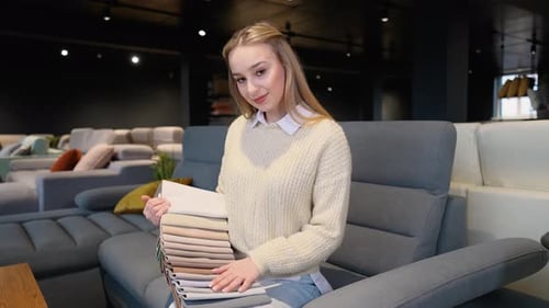 Woman Selects Fabric Swatches in Modern Furniture Store