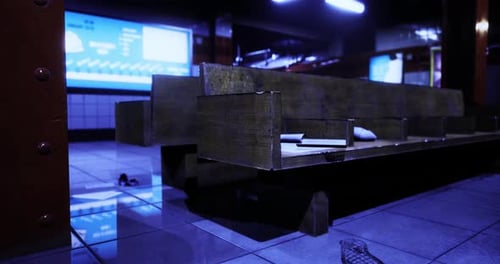 Wooden Seating Area in Modern Indoor Space with Digital Screens Illuminated