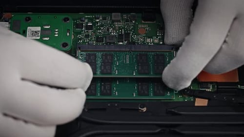 Ein Techniker in weißen Handschuhen ersetzt RAM-Boards in einem modernen und leistungsstarken autorisierten Laptop-Kundendienst