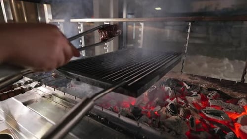 Chef Turning Over with Tong Meat During Grilled on Barbecue