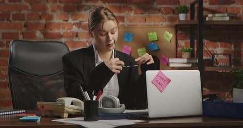 Young Businesswoman in Office with Brick Wall Background