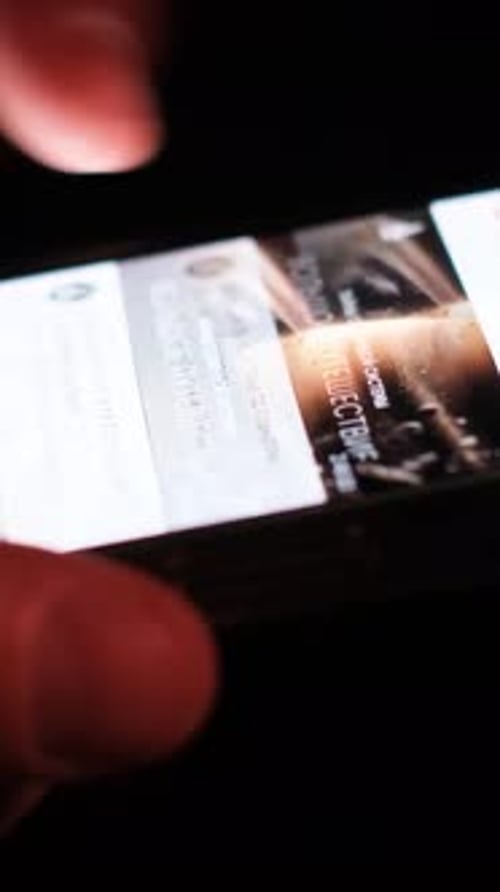 Gros plan d'un homme regardant un téléphone portable la nuit et naviguant sur un réseau social