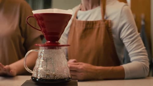 Unrecognizable Baristas Chatting While Making Coffee