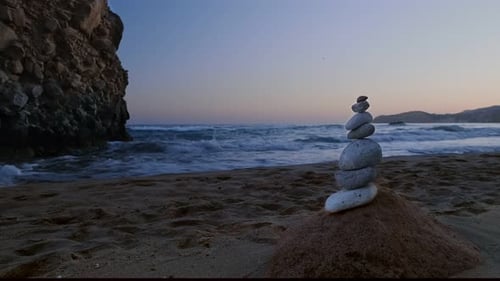 Balance Stones on Beach at Sunset Rock and Sea Waves in Background Concept of Zen Relax Meditation