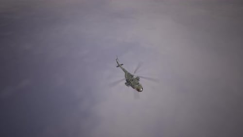 Military Attack Helicopter Flying High Above in Overcast Sky, Top View