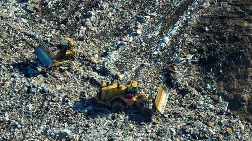 Aerial View of Bulldozers Moving Garbage in Dump