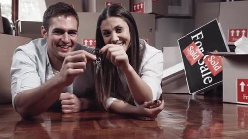 Happy Couple Lying on Floor with New House Keys