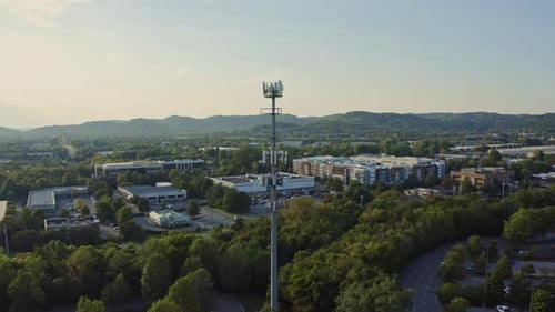 Antena 4K girando em torno da torre de comunicação do celular 5G à tarde