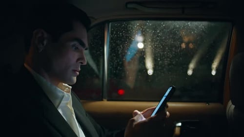 Man Using Smartphone in Car at Night