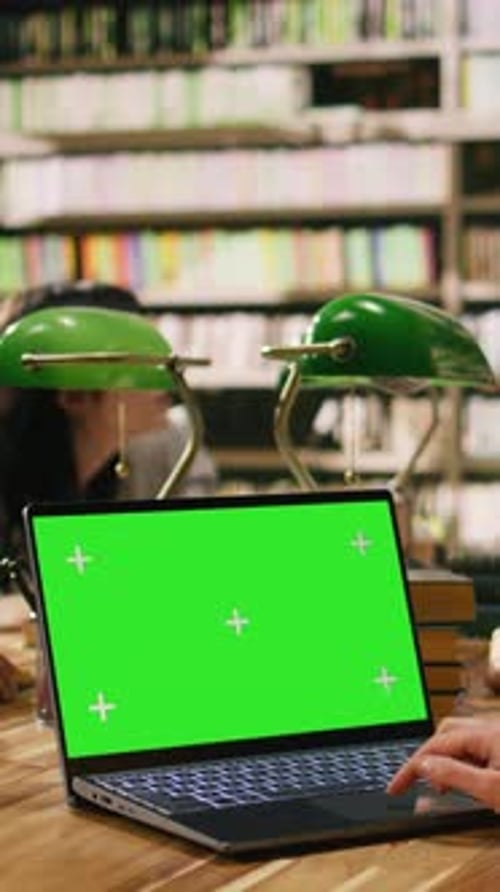 Vertical Video Chroma Key Green Screen on Laptop Near Student Hand on Wooden Desk