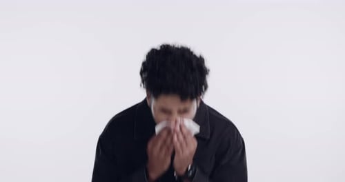 Young Man Sneezing and Using Tissue