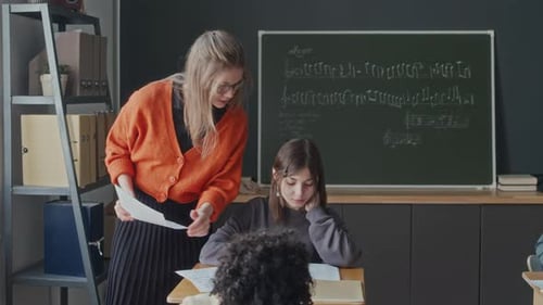 Female Teacher Helping Students with Exercise during Music Class