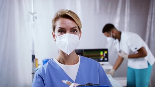 Doctors and Covid-19 Infected Patient in Bed in Hospital, Looking at Camera