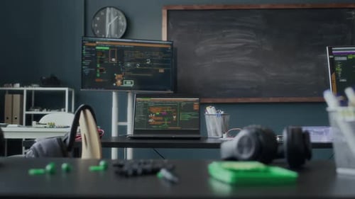 Programming Class with Laptops Displaying Software and Chalkboard