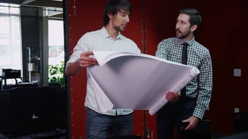 Cheerful young businessmen discuss e commerce technology in modern office