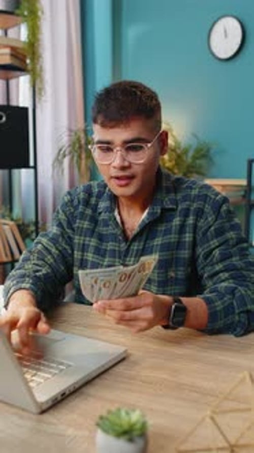 Business Man Counting Money Cash and Using Laptop Calculates Dividends Profits Finances at Office