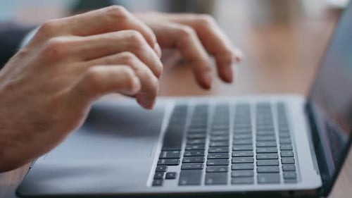 Hands Working on Laptop Keyboard in Office