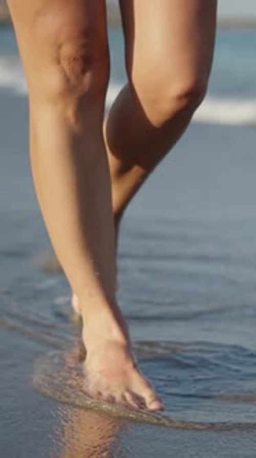 Legs Walking Along the Seashore Getting Wet