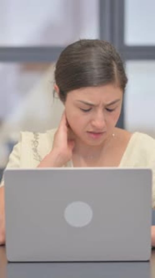 Woman Experiencing Neck Pain While Using Laptop
