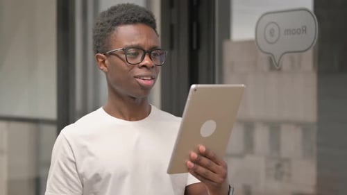 Online Video Chat on Tablet by Casual Young African Man