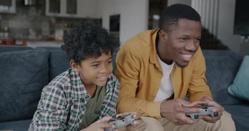 Father and Son Gaming Together at Home