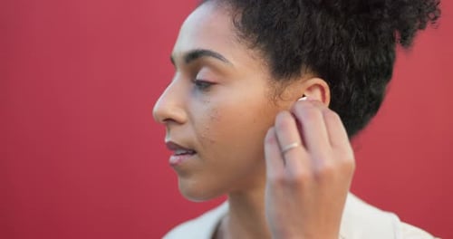 Woman Puts in Wireless Earbuds for Listening