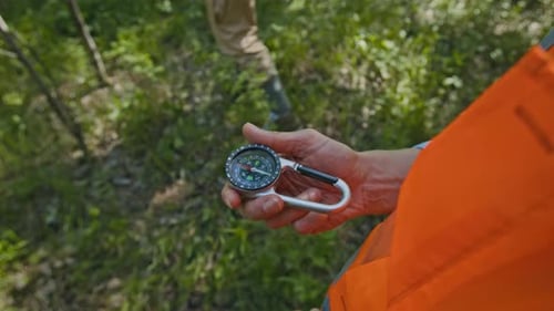 Professional Rescuer Using Compass in Woods