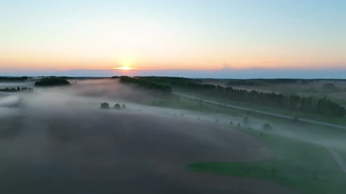Aerial panoramic view of a foggy rural landscape at sunrise
