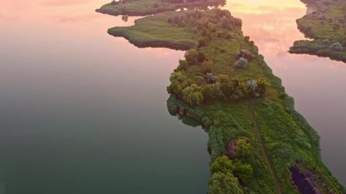 Aerial tilt up footage of sunrise on lake in city