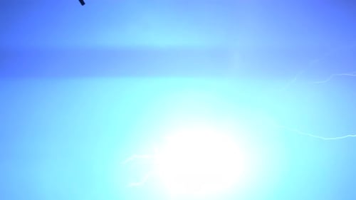 Flashes of lightning in the night sky among thunderclouds.