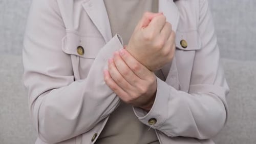 Adult Rubbing Wrist Due to Pain and Inflammation