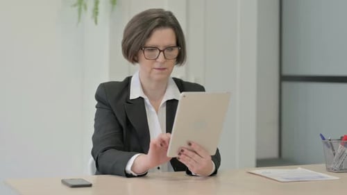 Old Businesswoman Celebrating Win on Digital Tablet