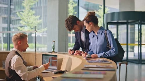 Clients Writing Hotel Papers at Reception Lobby Young Couple Tourists Check in