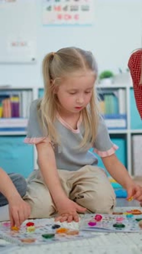 Young Children Sitting on the Floor Engaged in a Colorful Educational Activity with Various Game