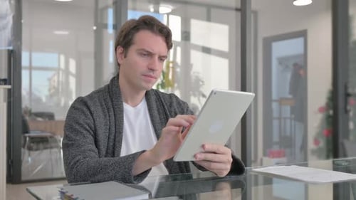 Young Man Using Digital Tablet in Office