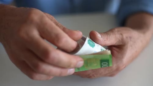Closeup Top View of Unrecognizable Senior Adult Male with Wrinkled Hands Counting Russian Ruble