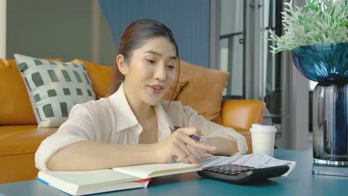 Smiling young woman hand press calculator to calculate income expenses and plans for spending money