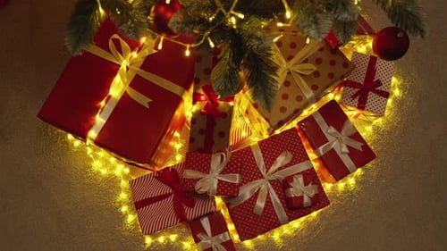 Wrapped Christmas Gifts Under Glowing Tree at Night